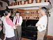 Steve and Greg listening to Ron, the tour guide, at Scotty's Castle in front of a 6 burner gas stove