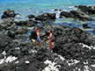 Johnny & Miranda standing on L=ava rock in ocean